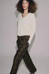 Pantalón de tiro alto con diseño fluido y estampado de cuadros en tonos oscuros. Presenta pliegues frontales, bolsillos delanteros con solapa y cierre frontal con cremallera, botón y ganchos metálicos.