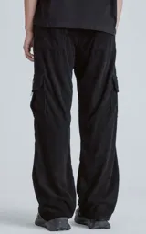 Pantalon cargo de corderoy negro con corte regular, cintura elástica y seis bolsillos, incluyendo dos bolsillos laterales con solapa.