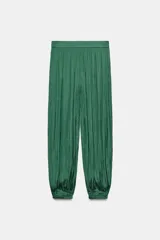 Pantalón de tiro medio confeccionado en tejido satinado verde, con diseño bombacho y bajos acabados en puño elástico. Cuenta con cierre lateral con cremallera oculta en costura.
