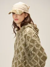 Chaqueta de algodón con diseño de textura desflecada en forma de rombos, cierre frontal con cremallera, cuello alto y puños elásticos.