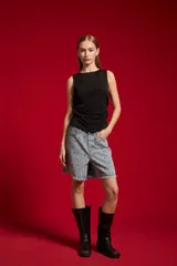 Musculosa blanca sin mangas de poliéster, con cuello bote y diseño ajustado al cuerpo.