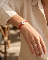 Pulsera de hilo rojo en macramé con dije central de Hamsa en nácar y plata 925, con terminaciones en esferas de plata.