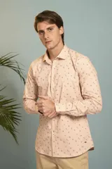 Camisa de manga larga en color salmón con estampado de pequeños motivos geométricos oscuros, cuello clásico y cierre frontal con botones.