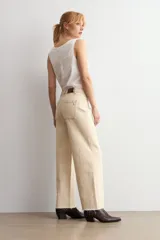 Jean de corte culotte y tiro medio, color beige, con diseño de perneras anchas y terminación desmechada en el bajo.