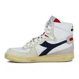 Zapatilla de caña alta Diadora Heritage modelo Mi Basket, color blanco con detalles en azul marino, beige y rojo. Presenta un acabado envejecido en la suela de goma. En la lengüeta se observa un gráfico en blanco y negro de una figura masculina.