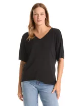 Blusa de silueta fluida con escote en V, manga japonesa corta y costura central vertical en el frente. Confeccionada en tejido de punto con acabado mate, presenta un diseño con largo asimétrico, siendo más larga en la espalda.