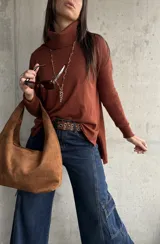 Polera de tejido de punto color chocolate, con cuello alto, mangas largas y diseño con tajos laterales en el ruedo.