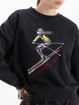 Buzo de cuello redondo y mangas largas, con calce amplio y largo a la cadera. Presenta una estampa frontal con diseño de esquiadora y la frase 'Après Ski', junto con un logo bordado en la espalda.