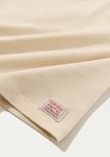 Blusa extragrande de tejido de punto en color beige, con cuello redondo y mangas cortas de corte holgado.