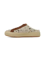 Zueco destalonado de estilo deportivo, confeccionado en cuero con pelo con estampado animal print tipo vaca en tonos blancos y marrones. Posee cordones marrones, detalles en cuero marrón y suela de plataforma de goma en tono tostado.