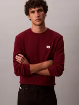 Remera de manga larga Calvin Klein en tejido térmico de punto con textura tipo nido de abeja, color bordó, de corte regular con cuello redondo y puños acanalados. Cuenta con un pequeño parche con el logo de la marca en el pecho.