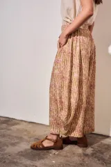 Babucha fluida de tiro alto con cintura elástica, diseño de rayas combinadas con estampado tipo toile de jouy en tonos beige y rojo.