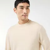 Sweater de punto de cuello redondo, manga larga y diseño liso, con puños y ruedo acanalados.
