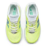 Championes de running New Balance modelo FuelCell Rebel v5, color amarillo neón con detalles en blanco y gris. Presentan una entresuela voluminosa con tecnología FuelCell para mayor amortiguación y propulsión, parte superior de malla transpirable con diseño aerodinámico y logo lateral característico.