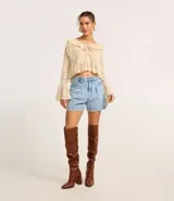 Short de jean estilo baggy con pliegues delanteros, cintura alta, cierre de botón y cremallera, y bolsillos funcionales en frente y espalda.