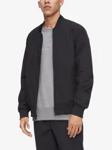 Campera bomber negra Calvin Klein de poliéster y algodón, con cuello redondo, cierre frontal, bolsillos laterales con cierre, logo en el pecho y ribete de punto acanalado.