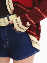 Cardigan tejido de punto jacquard en tonos bordó y rojo con rayas, de corte oversize, cuello redondo y cierre frontal con botones carey. Presenta detalles bordados en contraste y monograma en la espalda.