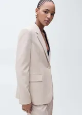 Blazer estructurado de corte recto, color beige, con cuello de solapa, cierre frontal de un botón, bolsillos laterales con solapa y mangas largas con puños abotonados.