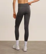Legging deportiva de tiro alto confeccionada en tejido seamless color gris melange. Presenta un diseño ajustado con paneles texturizados en los laterales que ofrecen un efecto modelador y levanta pompis.