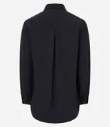Camisa básica de mujer confeccionada en tricolina de algodón, con cuello solapa, cierre frontal de botones y mangas largas con puños abotonados.