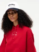 Gorra de béisbol de seis paneles confeccionada en algodón, con visera en contraste color negro y detalle de ribete tricolor. Presenta bordado frontal con el logo de Cadillac en fuente script, seguido de la inscripción Formula 1 Team y el logo de Tommy Hilfiger.