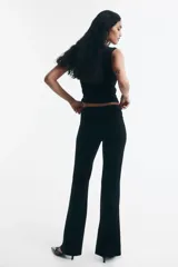 Top sin mangas de velour negro, ajustado al cuerpo, con escote cruzado drapeado y frunces laterales.