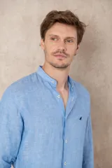 Camisa de lino color beige con cuello mao, corte slim fit y mangas 3/4 con botón para sujetar.