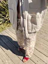 Pantalón slouchy color beige de gabardina de algodón con bordado floral marrón.