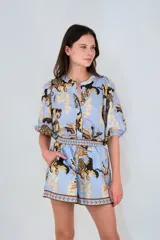 Short celeste con estampado de tigres y hojas, cintura elástica y bolsillos laterales.