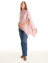 Poncho tejido de punto con diseño asimétrico y aberturas laterales para los brazos.