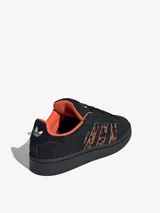 Championes Adidas Campus 00s negros con las tres tiras laterales en animal print y contrafuerte naranja.