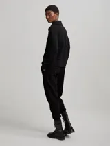 Sweater deportivo negro con cierre de medio largo en el cuello y textura acanalada.