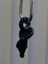Aros colgantes compuestos por una argolla de acero quirúrgico y un dije de cristal de Murano negro con forma de flor cala.