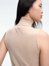 Top sin mangas al cuerpo confeccionado en tejido de viscosa con micro lentejuelas brillantes. Presenta cuello alto y diseño elástico, ideal para diversas ocasiones.