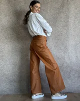 Pantalón de jean estilo wide leg con costuras verticales frontales, tiro alto y bolsillos laterales.