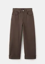 Jeans balloon de tiro medio en color marrón, de diseño largo con cinco bolsillos, trabillas y bajo vuelto. Cuenta con cierre delantero de cremallera y botón.