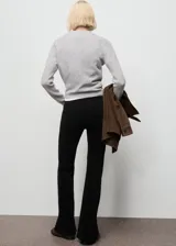 Jeans de terciopelo color negro, tiro alto y estilo flare, con diseño de cinco bolsillos y trabillas para cinturón.