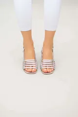 Sandalias de cuero doradas con tiras finas horizontales en el empeine, pulsera con hebilla al tobillo y tacón cuadrado.