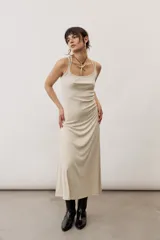 Vestido largo color verde suave, sin mangas, con escote redondo y silueta al cuerpo que se ensancha levemente hacia el dobladillo.