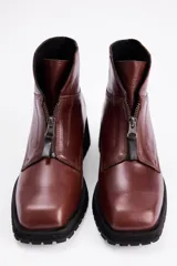 Borcegos de cuero color marrón con cierre frontal y suela track negra.