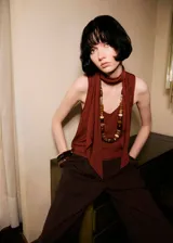 Blusa sin mangas color bordó, con cuello escotado y detalle de fular integrado al cuello. Presenta un diseño recto y tirantes anchos.