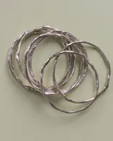 Pulsera rígida de bronce y alpaca, adaptable a muñecas de 13 a 15 cm.