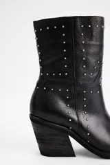 Bota de caña media confeccionada en cuero vacuno negro, con diseño de estilo western, punta cuadrada y detalle de tachas metálicas plateadas distribuidas en la superficie. Cuenta con un taco cuadrado de madera.
