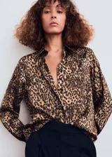 Camisa de tejido satinado con estampado de leopardo, corte recto, manga larga con puños abotonados, cuello camisero y cierre delantero con botones.