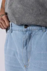 Jean cargo de corte baggy y tiro medio, confeccionado en denim de color celeste con lavado soft. Presenta bolsillos laterales tipo cargo con solapa, costuras reforzadas en las rodillas y un calce holgado con caída relajada.