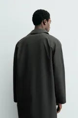 Gabardina impermeable de corte regular fit en color verde militar, con cuello solapa, manga larga con puño ajustable con botones a presión y bolsillos de vivo en la cadera. Cierre frontal con cremallera oculta por solapa con botones a presión.