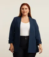 Blazer alargado azul marino de crepé, sin cierre, con solapas y mangas fruncidas.