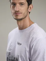 Remera gris con estampado de una fotografía en blanco y negro y la palabra 'Tokyo' en la parte superior.