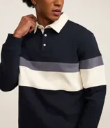 Saco masculino de algodón con diseño de bloques de color en azul marino, gris y blanco. Presenta cuello polo con botones, manga larga y puños ajustados.