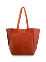 Cartera tipo shopper de cuero color terracota, sin forro y con terminaciones al corte. Cuenta con bolsillo interior con cierre.
